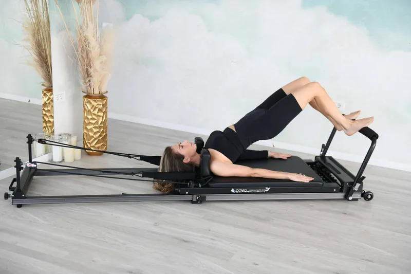 Cursantă care execută un exercițiu de Pilates pe Reformer, în sala Penthouse